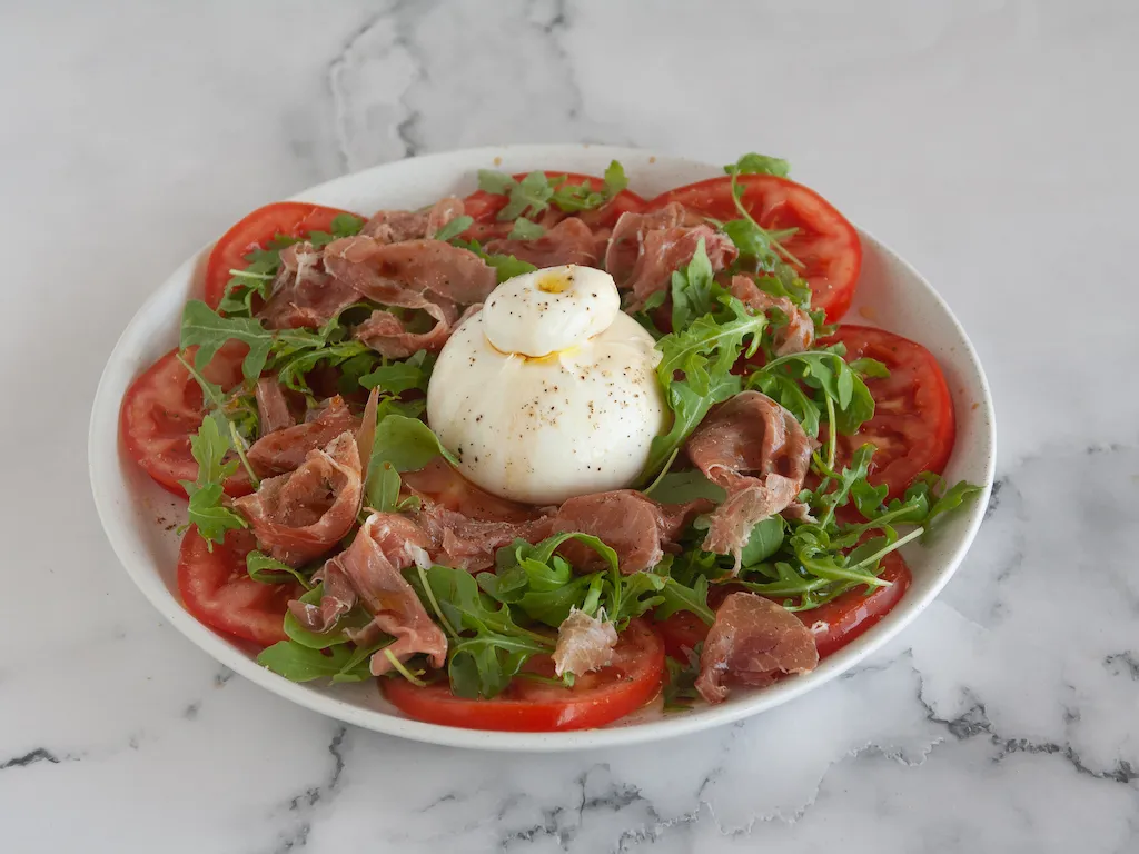 Ensalada de tomate, burrata y jamón con rúcula