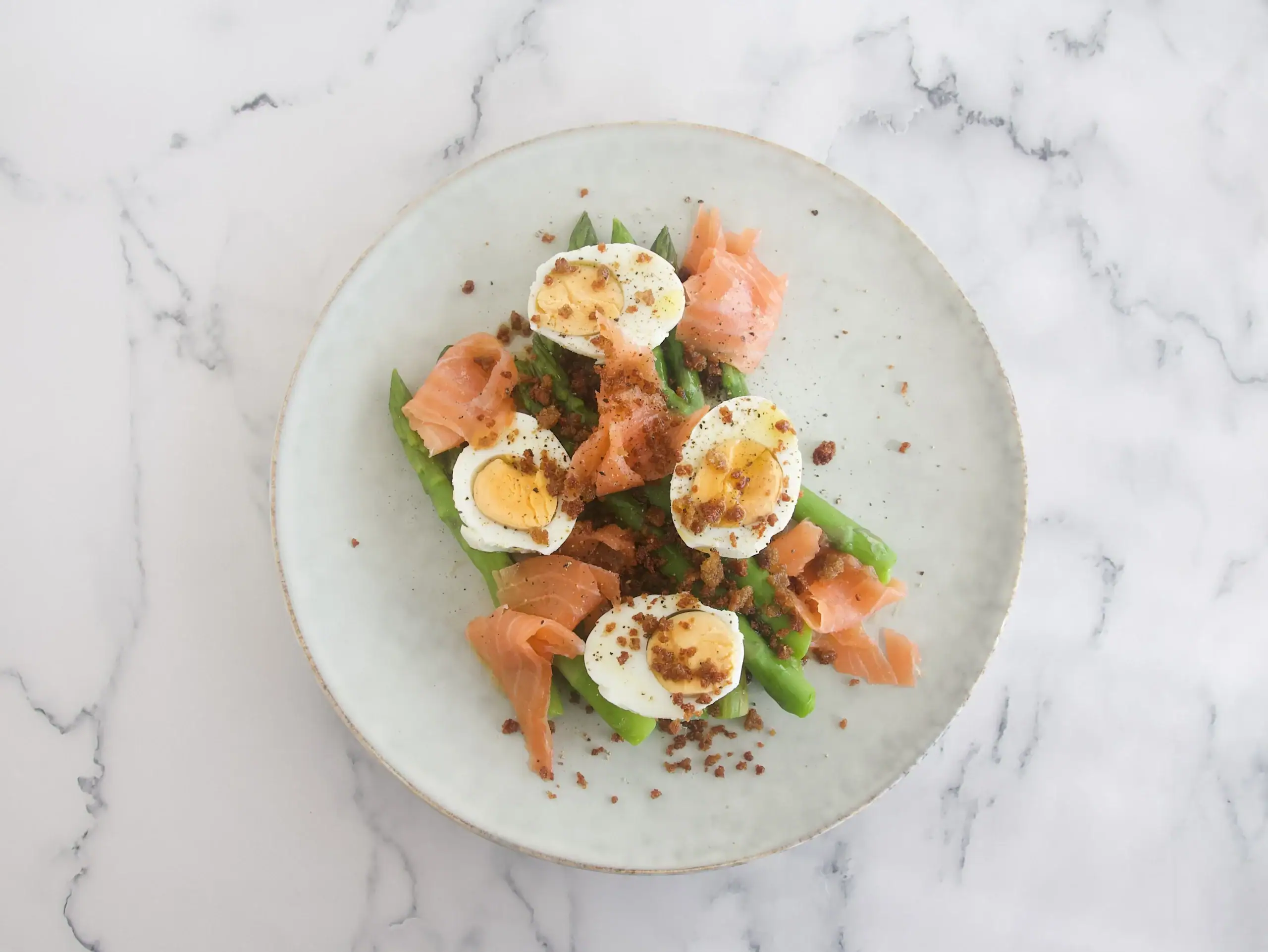 Espárragos con huevo, migas de anchoa y salmón ahumado