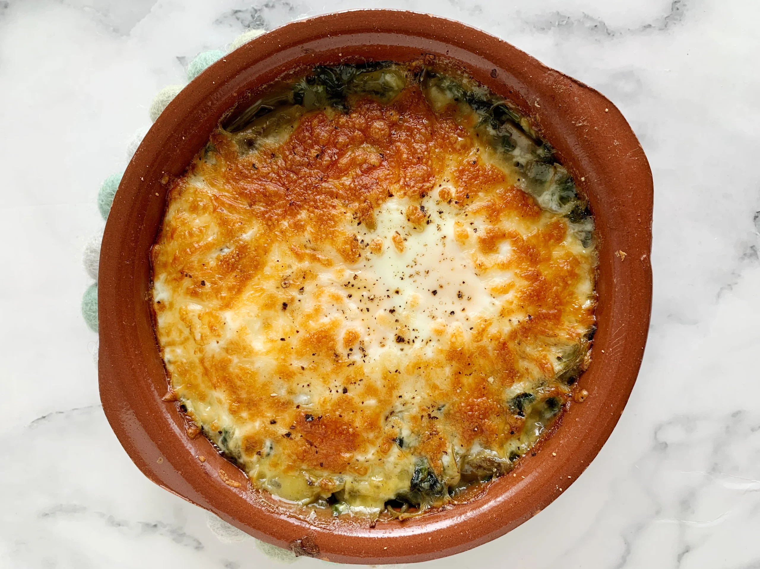 Huevos al horno con espinacas y alcachofas