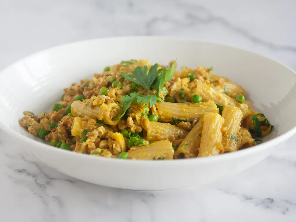 Pasta a la crema con proteína vegetal texturizada y guisantes