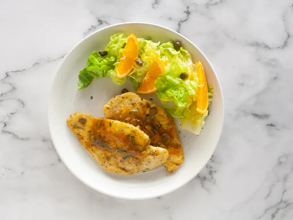Pollo con salsa de naranja, alcaparras y estragón