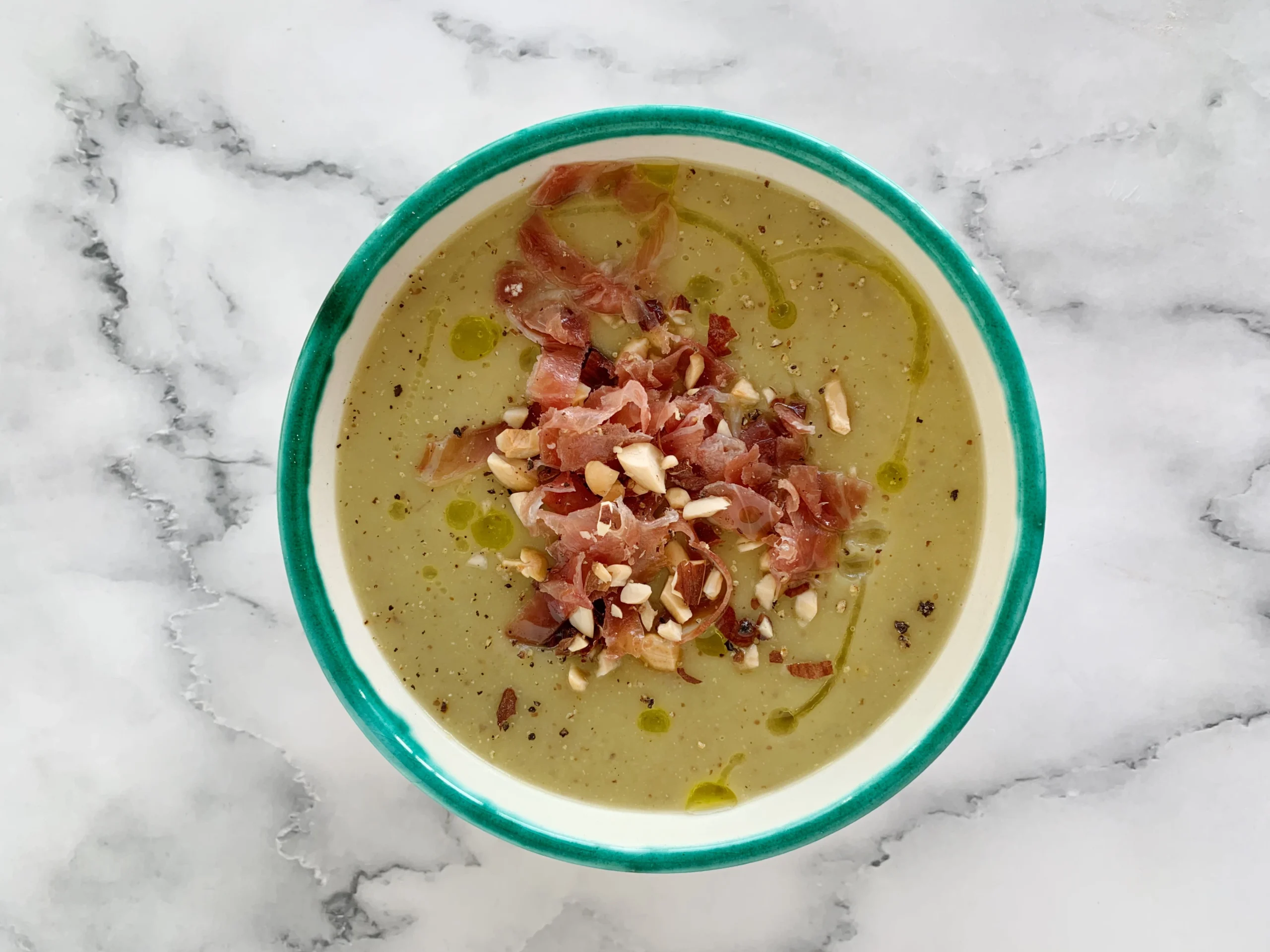 Sopa cremosa de puerros con virutas de jamón y avellanas