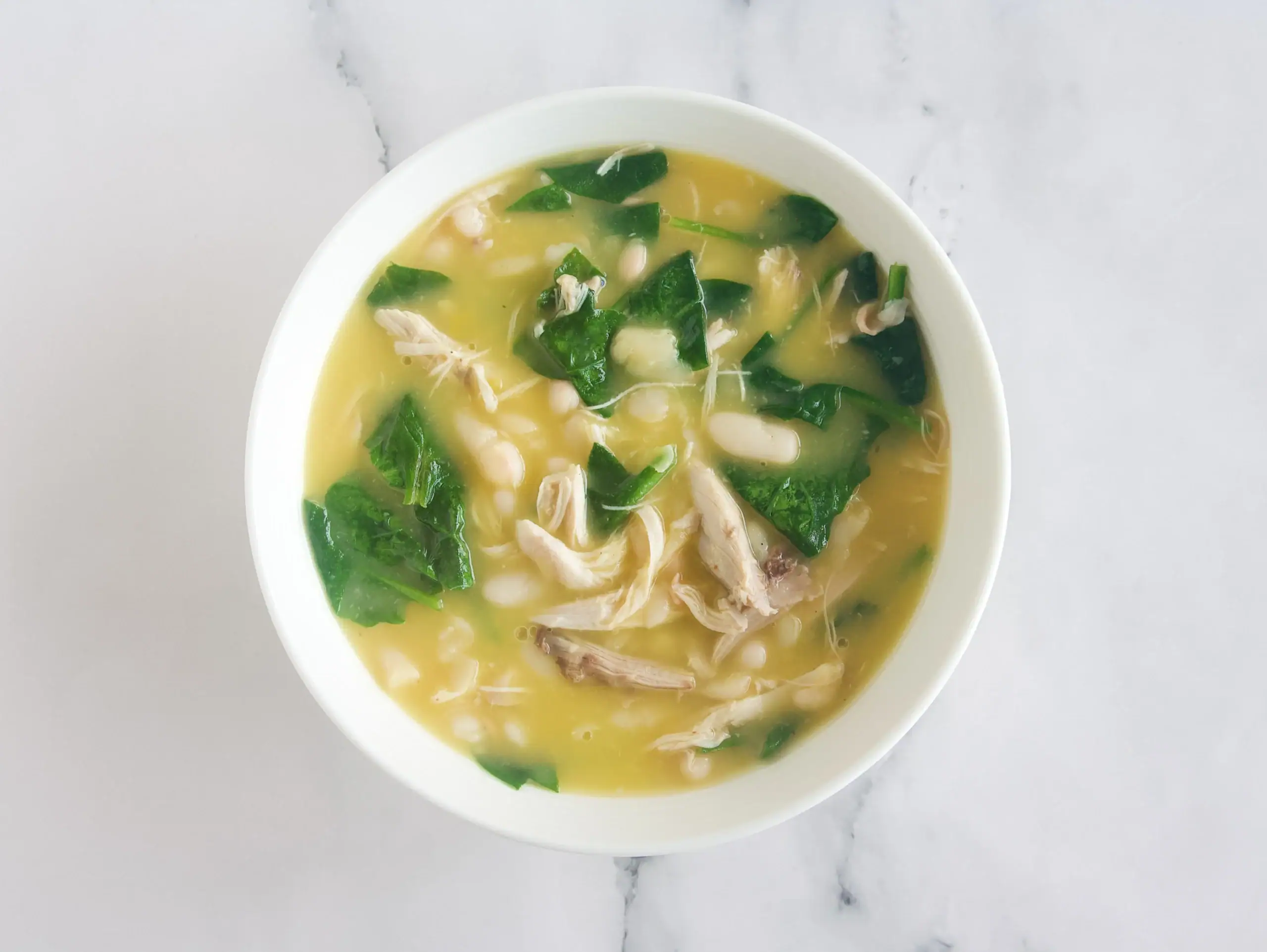 Sopa de pollo, alubias blancas y espinacas al limón