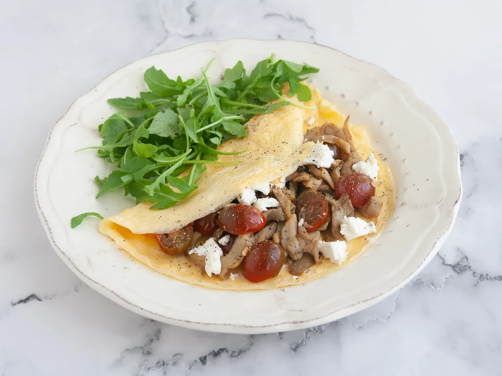 Tortilla abierta de setas, tomate y queso de cabra